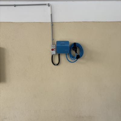 מטען חשמלי עם כבל כחול על קיר