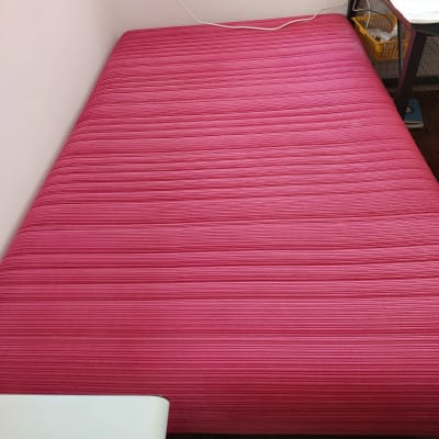 מזרן ורוד בחדר עם שולחן קטן