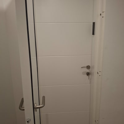 דלת לבנה עם ידית מתכת ומנעול