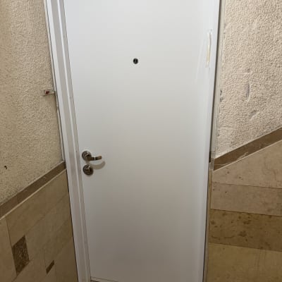 דלת לבנה עם ידית מתכת במסדרון