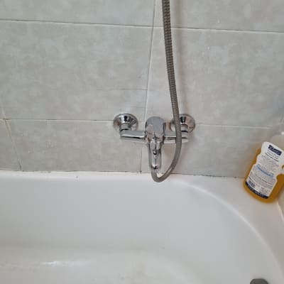 ברז אמבטיה עם בקבוק סבון על שפת האמבטיה