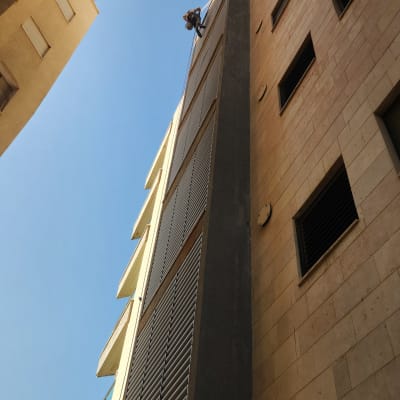 אדם מבצע עבודות בגובה על בניין גבוה