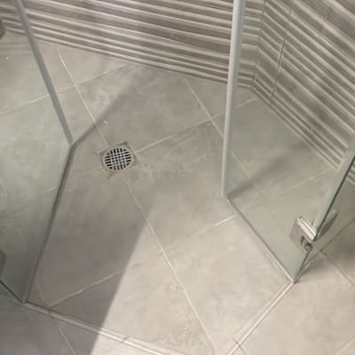 מקלחון עם דלתות זכוכית ורצפת אריחים