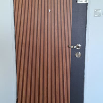 דלת עם ציפוי עץ וידית מתכת כסופה