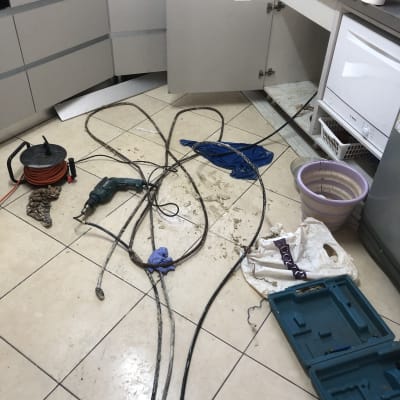 כלים וציוד אינסטלציה במטבח, כבלים וצינורות על הרצפה