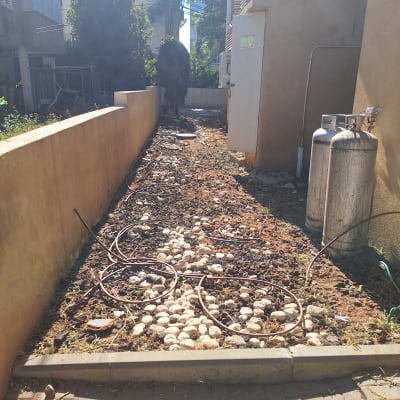 צינורות השקיה על אדמה עם אבנים קטנות
