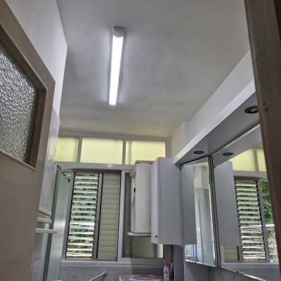 חדר אמבטיה עם ארון, כיור ומנורה חדשה