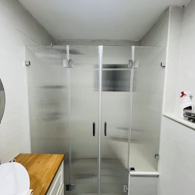 מקלחון זכוכית עם דלתות וידית בחדר אמבטיה מודרני