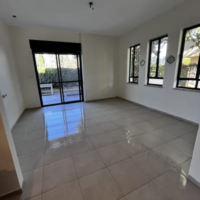 חדר ריק עם רצפת אריחים וחלונות גדולים