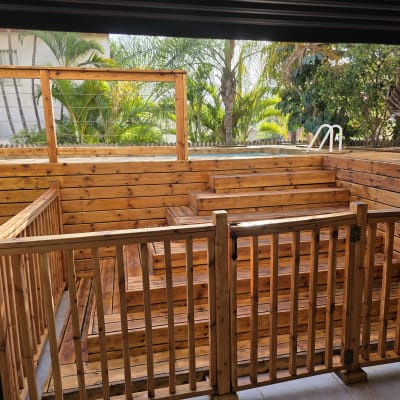 דק עץ ובריכה בגינה עם מעקה עץ