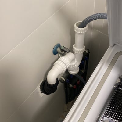 צינור פלסטיק לבן מחובר למכונת כביסה