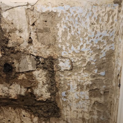 קיר מתקלף עם טיח חשוף בתהליך שיפוץ