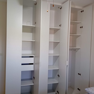 ארון לבן עם מדפים ודלתות פתוחות