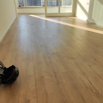 רצפת עץ חדשה בחדר ריק עם קסדה על הרצפה