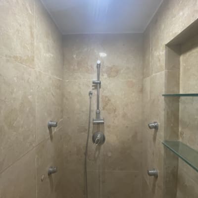 מקלחת עם ראש טוש ומדפים מזכוכית