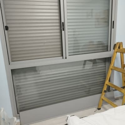 תריסים אפורים סגורים על חלון זכוכית