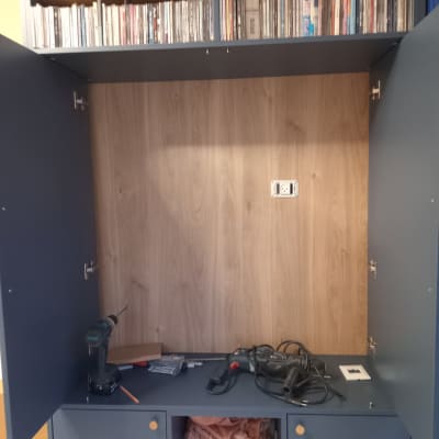 ארון פתוח עם כלים חשמליים ומדפי דיסקים