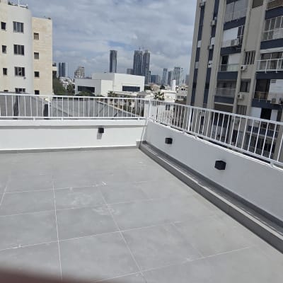 מרפסת ריקה עם רצפת אריחים ומעקה לבן