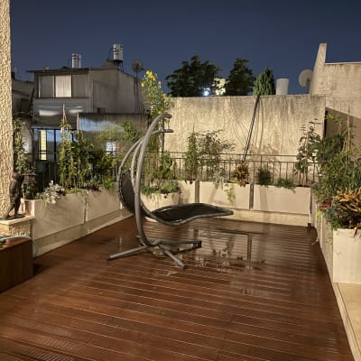 מרפסת עם צמחים ופרחים בערוגות