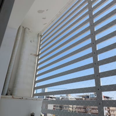 רשת מתכת על חלון למניעת כניסת יונים