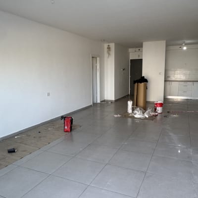 חדר עם כלים לצביעה, דלי צבע ומברשת על הרצפה