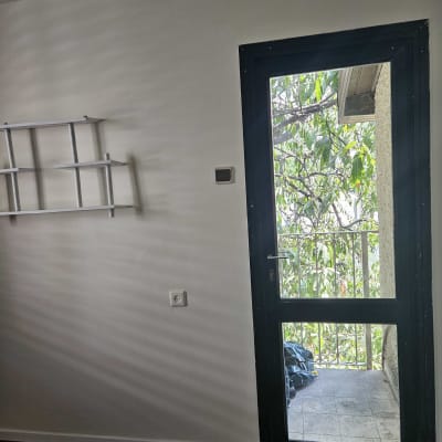 דלת זכוכית עם נוף לעץ ומרפסת קטנה