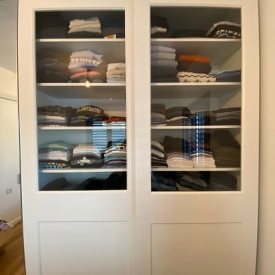 ארון בגדים עם מדפים מסודרים בבגדים מקופלים