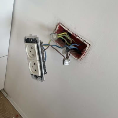 שקע חשמלי פתוח עם חוטים חשופים בקיר