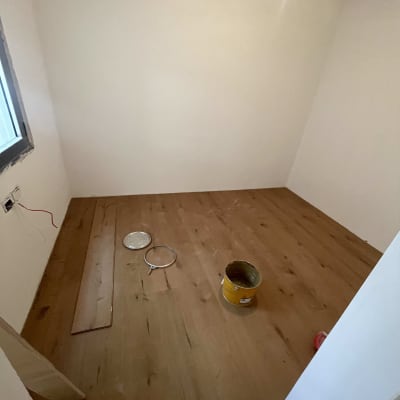 חדר עם פרקט עץ וכלי עבודה על הרצפה