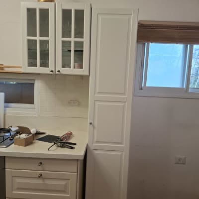 ארונות מטבח לבנים עם כלי עבודה על השיש