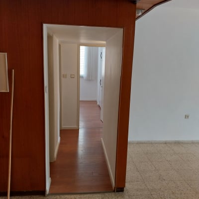 מגב כחול על רצפה ליד קיר עץ