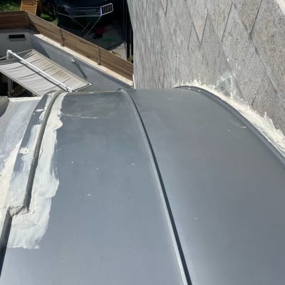 איטום גג מתכת עם חומר לבן לאורך התפרים