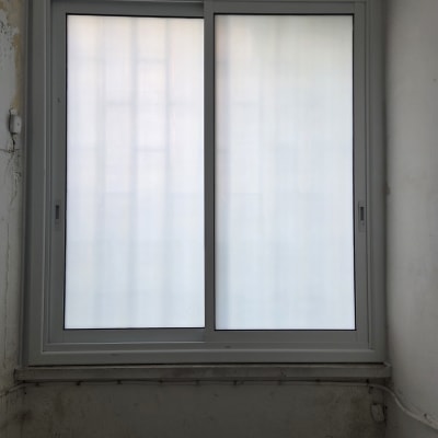 חלון אלומיניום עם מסגרת לבנה בקיר פנימי