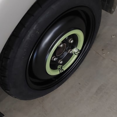 גלגל רכב עם חישוק מתכת שחור ופס ירוק