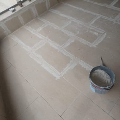רצפה מרוצפת עם דלי חומר ומרית
