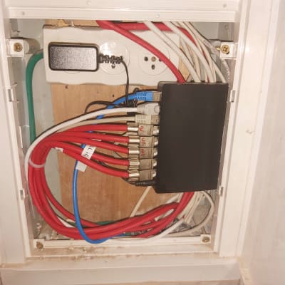 ארון תקשורת עם כבלים אדומים ולבנים מחוברים למפצל