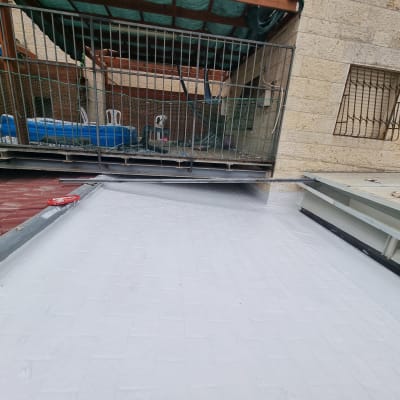 גג אטום בצבע לבן עם כלי עבודה אדום