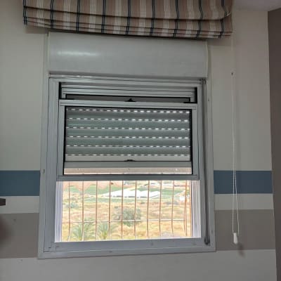 תריסים אפורים פתוחים חלקית עם חוט משיכה לבן