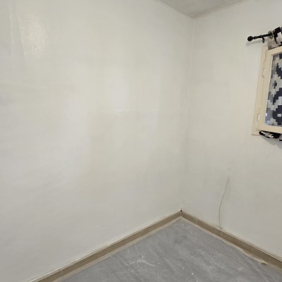 חדר עם קירות צבועים בלבן ויריעת מגן על הרצפה