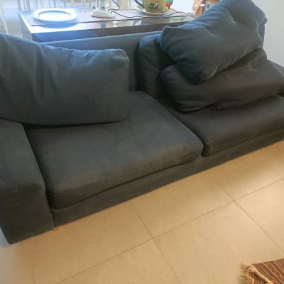 ספה כהה עם כריות בסלון מואר