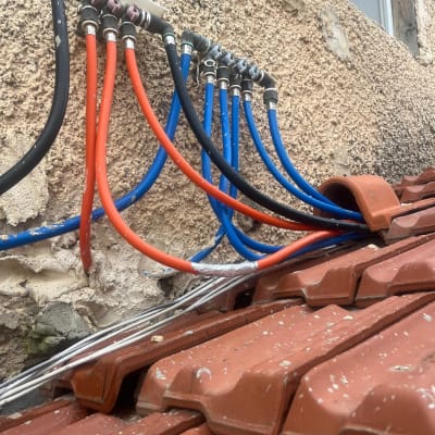 צינורות מים צבעוניים מחוברים לקיר חיצוני