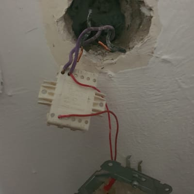 חוטי חשמל יוצאים מקיר עם מתג חשמלי