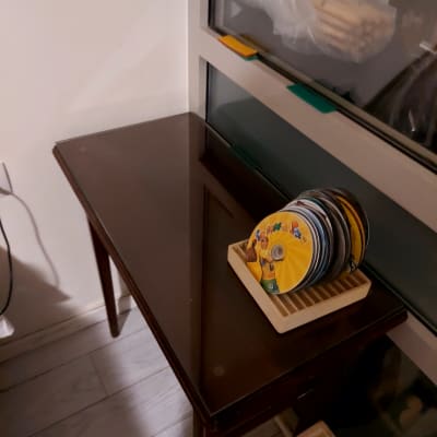 שולחן זכוכית ליד חלון עם מחזיק דיסקים