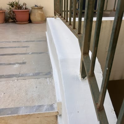 מעקה מתכת על מדרגה צבועה בלבן