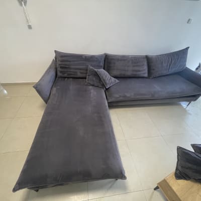 ספה אפורה גדולה עם כריות על רצפת אריחים