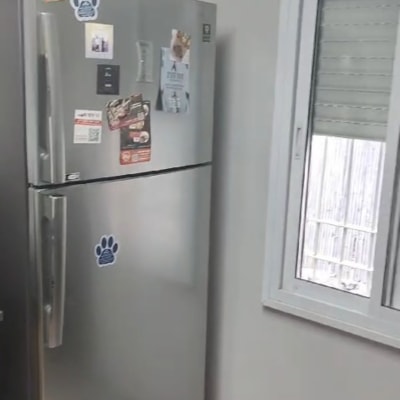 מקרר עם מגנטים על דלתותיו ליד חלון