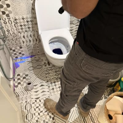 אדם עם פנס בודק אסלה בחדר אמבטיה