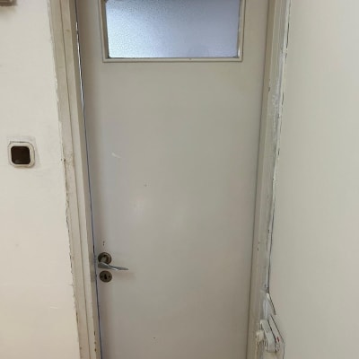 דלת צבועה בצבע לבן עם חלון קטן