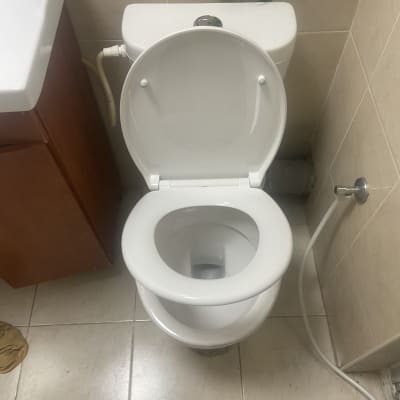 אסלה פתוחה עם צינור מים ליד הקיר