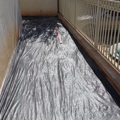 יריעת פלסטיק שחורה פרוסה על הקרקע בגינה